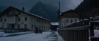 Movie still from “Where Eagles Dare” (1968), directed by Brian G. Hutton – A man riding a motorcycle down a snowy street; Extreme Wide shot, Low angle