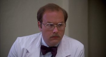 Movie still from “Where the Buffalo Roam” (1980), directed by Art Linson – A man in a white lab coat and a bow tie; Close Up shot, Low angle