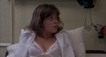 Movie still from “Where the Buffalo Roam” (1980), directed by Art Linson – A woman in a white bra and white jacket; Close Up shot, Low angle