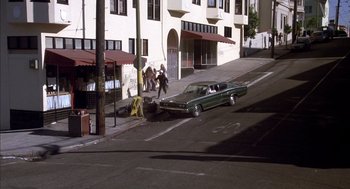Movie still from “Where the Buffalo Roam” (1980), directed by Art Linson – A car that is sitting on the side of the street; Extreme Wide shot, High angle