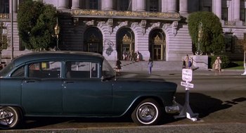Movie still from “Where the Buffalo Roam” (1980), directed by Art Linson – An old car parked on the side of the street; Wide shot, High angle