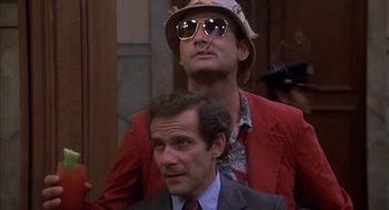 Movie still from “Where the Buffalo Roam” (1980), directed by Art Linson – A man in a suit and a man in a hat and sunglasses; Close Up shot, Low angle
