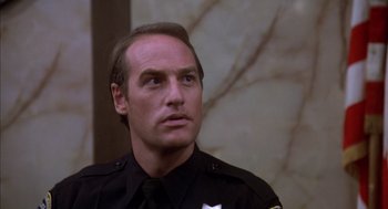 Movie still from “Where the Buffalo Roam” (1980), directed by Art Linson – A police officer is looking into the distance; Close Up shot, Low angle