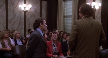 Movie still from “Where the Buffalo Roam” (1980), directed by Art Linson – A group of men standing in front of a crowd; Medium shot, Over the shoulder angle