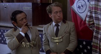 Movie still from “Where the Buffalo Roam” (1980), directed by Art Linson – A man in a suit and tie with a necklace around his neck; Close Up shot, Low angle