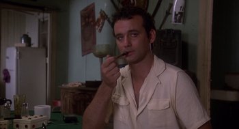 Movie still from “Where the Buffalo Roam” (1980), directed by Art Linson – A man in a white shirt is eating something; Close Up shot, Low angle