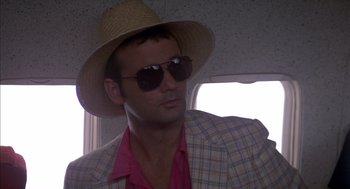 Movie still from “Where the Buffalo Roam” (1980), directed by Art Linson – A man wearing a straw hat and sunglasses; Close Up shot, Low angle