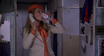 Movie still from “Where the Buffalo Roam” (1980), directed by Art Linson – A woman drinking a can of soda while talking on the phone; Medium shot, Low angle