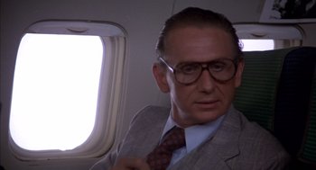 Movie still from “Where the Buffalo Roam” (1980), directed by Art Linson – A man in a suit and tie on a plane; Close Up shot, Over the shoulder angle