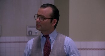 Movie still from “Where the Buffalo Roam” (1980), directed by Art Linson – A man wearing glasses and a vest and a tie; Close Up shot, Over the shoulder angle