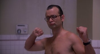 Movie still from “Where the Buffalo Roam” (1980), directed by Art Linson – A man with glasses is standing in a bathroom; Close Up shot, Low angle