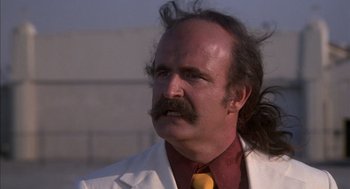 Movie still from “Where the Buffalo Roam” (1980), directed by Art Linson – A man in a white jacket and a yellow neck tie; Close Up shot, Low angle