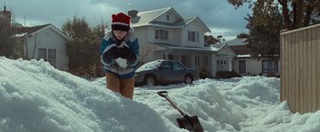Movie still from “Where the Wild Things Are” (2009), directed by Spike Jonze – A young boy standing next to a pile of snow in front of a house; Wide shot, High angle