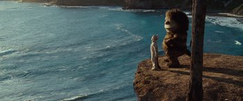 Movie still from “Where the Wild Things Are” (2009), directed by Spike Jonze – A man standing on a cliff next to a giant bear; Wide shot, Low angle