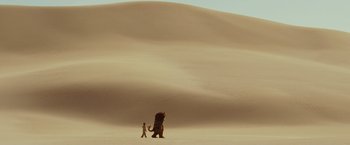 Movie still from “Where the Wild Things Are” (2009), directed by Spike Jonze – A man walking in the desert with a giant monster; Extreme Wide shot, High angle