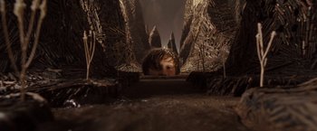 Movie still from “Where the Wild Things Are” (2009), directed by Spike Jonze – A boy is hiding in the woods looking at the camera; Wide shot, High angle