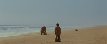 Movie still from “Where the Wild Things Are” (2009), directed by Spike Jonze – A man standing on the beach looking at a brown bear; Extreme Wide shot, Low angle