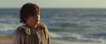 Movie still from “Where the Wild Things Are” (2009), directed by Spike Jonze – A young boy wearing a furry coat looking out at the ocean; Close Up shot, Over the shoulder angle
