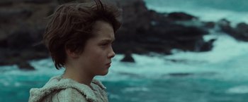 Movie still from “Where the Wild Things Are” (2009), directed by Spike Jonze – A young person is standing in front of a body of water; Close Up shot, Low angle