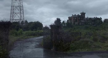 Movie still from “Where'd You Go, Bernadette” (2019), directed by Richard Linklater – An old gate in the middle of a road; Extreme Wide shot, Low angle