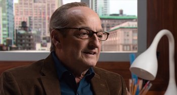 Movie still from “Where'd You Go, Bernadette” (2019), directed by Richard Linklater – An older man wearing glasses and a brown jacket; Close Up shot, Over the shoulder angle