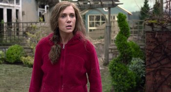 Movie still from “Where'd You Go, Bernadette” (2019), directed by Richard Linklater – A woman in a red jacket standing in front of a house; Medium shot, Over the shoulder angle
