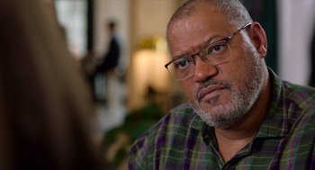 Movie still from “Where'd You Go, Bernadette” (2019), directed by Richard Linklater – An older man wearing glasses and a plaid shirt; Close Up shot, Over the shoulder angle