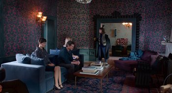 Movie still from “Where'd You Go, Bernadette” (2019), directed by Richard Linklater – A group of people sitting on a couch in a living room; Wide shot, High angle