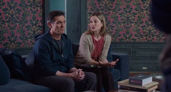 Movie still from “Where'd You Go, Bernadette” (2019), directed by Richard Linklater – A man and a woman sitting on a blue couch; Medium shot, Over the shoulder angle