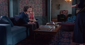 Movie still from “Where'd You Go, Bernadette” (2019), directed by Richard Linklater – A man and a woman sitting on a couch in a living room; Wide shot, High angle