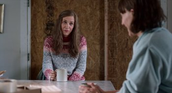 Movie still from “Where'd You Go, Bernadette” (2019), directed by Richard Linklater – A woman sitting at a table holding a mug; Medium shot, Over the shoulder angle