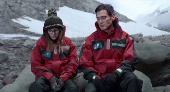 Movie still from “Where'd You Go, Bernadette” (2019), directed by Richard Linklater – A man and a woman sitting next to each other on a mountain; Medium shot, Over the shoulder angle