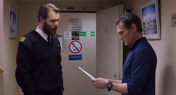 Movie still from “Where'd You Go, Bernadette” (2019), directed by Richard Linklater – Two men are standing in front of each other holding papers; Medium shot, Over the shoulder angle