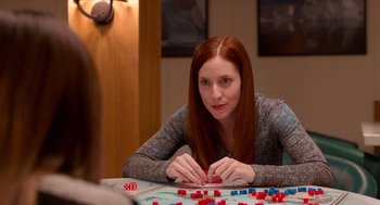 Movie still from “Where'd You Go, Bernadette” (2019), directed by Richard Linklater – A woman sitting at a table playing a board game; Close Up shot, Over the shoulder angle