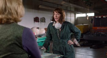 Movie still from “Where'd You Go, Bernadette” (2019), directed by Richard Linklater – A woman in a green coveralls and a white mask; Medium shot, Over the shoulder angle