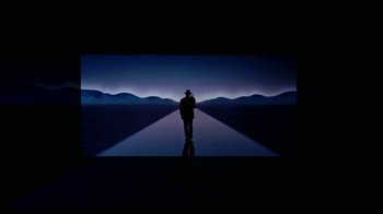 Movie still from “While You Were Sleeping” (1995), directed by Jon Turteltaub – A man standing in front of a large screen; Extreme Wide shot, Low angle
