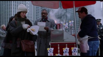 Movie still from “While You Were Sleeping” (1995), directed by Jon Turteltaub – A man and a woman standing in front of a hot dog stand; Medium shot, Over the shoulder angle