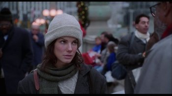 Movie still from “While You Were Sleeping” (1995), directed by Jon Turteltaub – A woman wearing a hat and scarf in a crowd of onlookers; Close Up shot, Over the shoulder angle