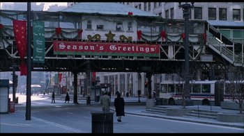 Movie still from “While You Were Sleeping” (1995), directed by Jon Turteltaub – People walking down a street under a bridge; Extreme Wide shot, Low angle
