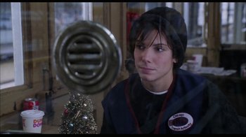 Movie still from “While You Were Sleeping” (1995), directed by Jon Turteltaub – A woman sitting in front of a christmas tree; Close Up shot, Over the shoulder angle