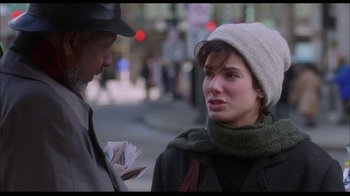 Movie still from “While You Were Sleeping” (1995), directed by Jon Turteltaub – A man and a woman talking on the sidewalk; Close Up shot, Over the shoulder angle