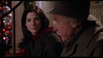 Movie still from “While You Were Sleeping” (1995), directed by Jon Turteltaub – An older man sitting next to a younger woman; Close Up shot, Over the shoulder angle