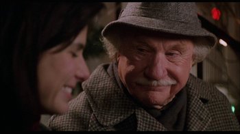 Movie still from “While You Were Sleeping” (1995), directed by Jon Turteltaub – An older man and a woman smiling at each other; Close Up shot, Over the shoulder angle