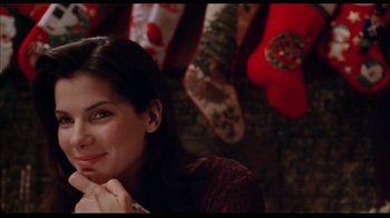 Movie still from “While You Were Sleeping” (1995), directed by Jon Turteltaub – A woman sitting in front of christmas stockings on the ground; Close Up shot, Over the shoulder angle