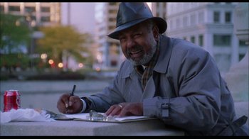 Movie still from “While You Were Sleeping” (1995), directed by Jon Turteltaub – An older man wearing a hat is writing on a piece of paper; Medium shot, Low angle