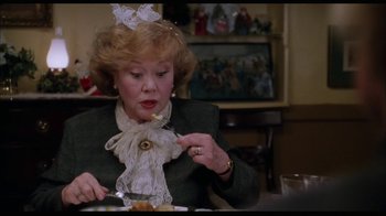 Movie still from “While You Were Sleeping” (1995), directed by Jon Turteltaub – An older woman is eating a piece of cake; Close Up shot, Over the shoulder angle