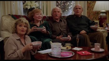 Movie still from “While You Were Sleeping” (1995), directed by Jon Turteltaub – A group of people sitting around a table with food; Medium shot, High angle