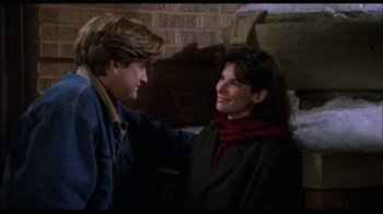 Movie still from “While You Were Sleeping” (1995), directed by Jon Turteltaub – A man and a woman standing next to each other; Medium shot, Over the shoulder angle