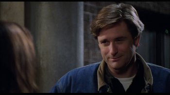 Movie still from “While You Were Sleeping” (1995), directed by Jon Turteltaub – A person wearing headphones and smiling; Close Up shot, Over the shoulder angle