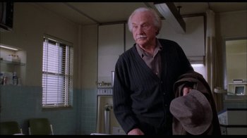 Movie still from “While You Were Sleeping” (1995), directed by Jon Turteltaub – An older man standing in front of a window; Medium shot, Low angle